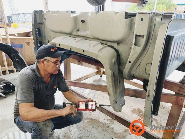 Technician measuring a vehicle frame