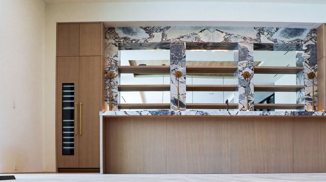 Bar counter against a marble wall with wood cabinetry